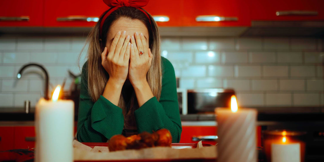 Stressed woman covering her face in a holiday kitchen, overwhelmed by Christmas cooking or planning.