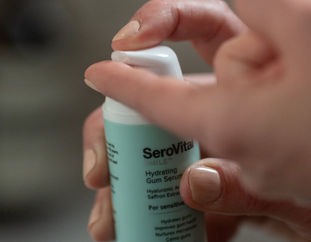 Hand holding a SeroVital skincare serum bottle with a blurred background