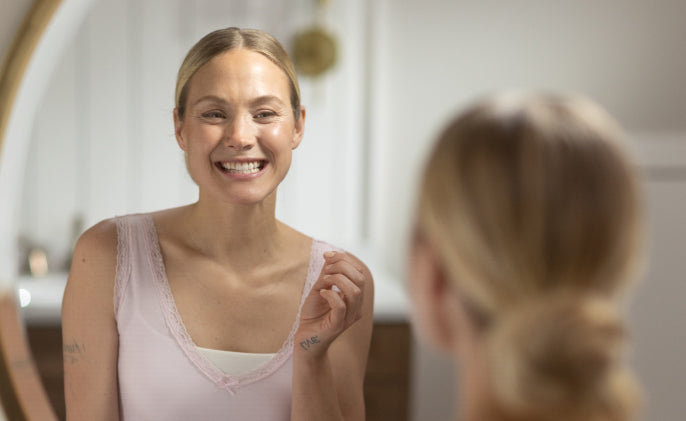 Woman smiling at herself in the mirror