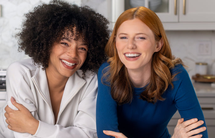 Two women smiling in a kitchen setting