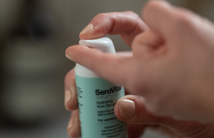 Hand holding a SeroVital skincare serum bottle with a blurred background