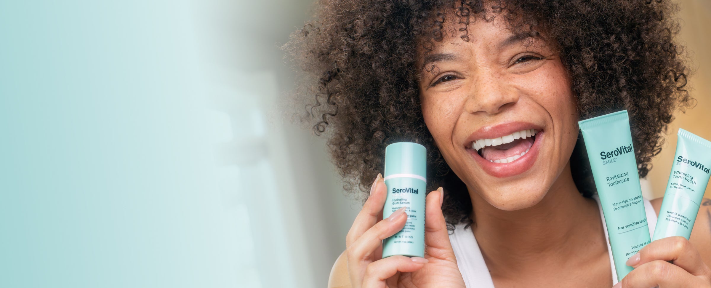 Woman holding SensiVita smile care products against a light background