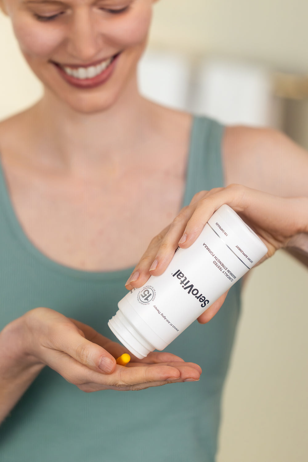 Woman holding a supplement bottle labeled 'Supplement' with a blurred background