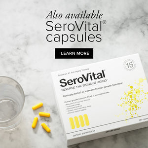 A box of HGH booster SeroVital lying on a marble background with 4 yellow capsules and a glass of water