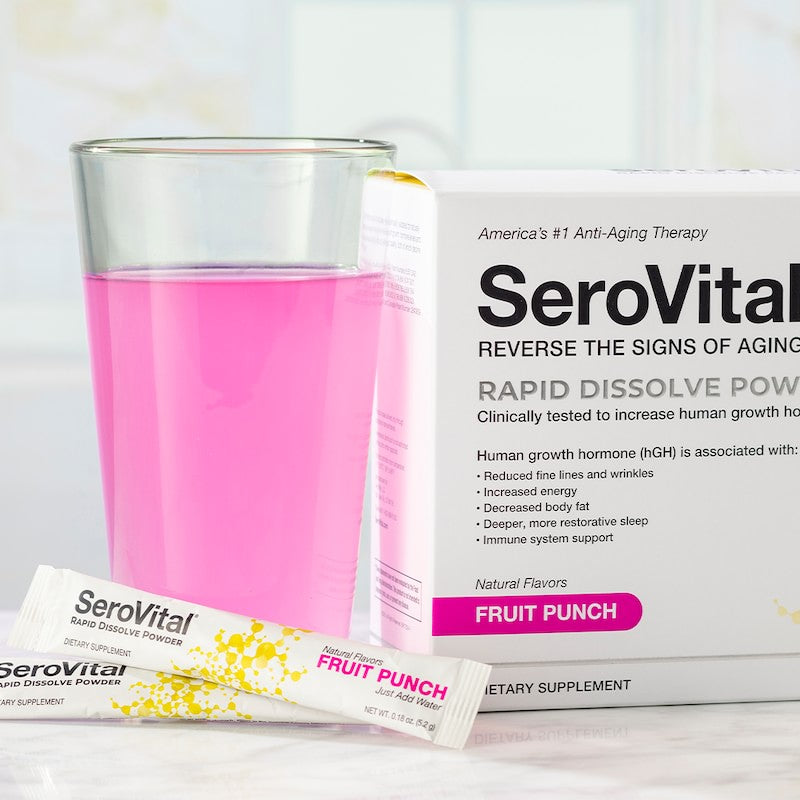 A box of SeroVital Rapid Dissolve Powder next to a glass of pink water showing how this vitality boosting formula looks when mixed with water.