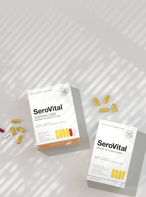 Two white boxes of SeroVital Advanced supplements and scattered capsules (yellow, white, pink) are shown on a light gray surface with window shadow patterns.
