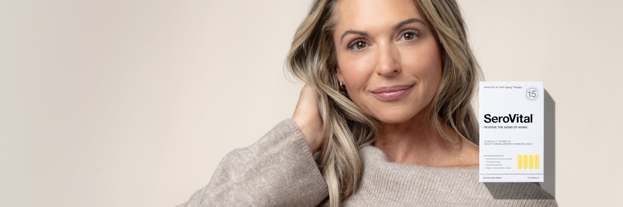 Woman in beige sweater holding a box of SeroVital anti-aging dietary supplement