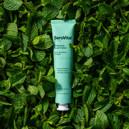 SeroVital tooth polish tube on a bed of green leaves