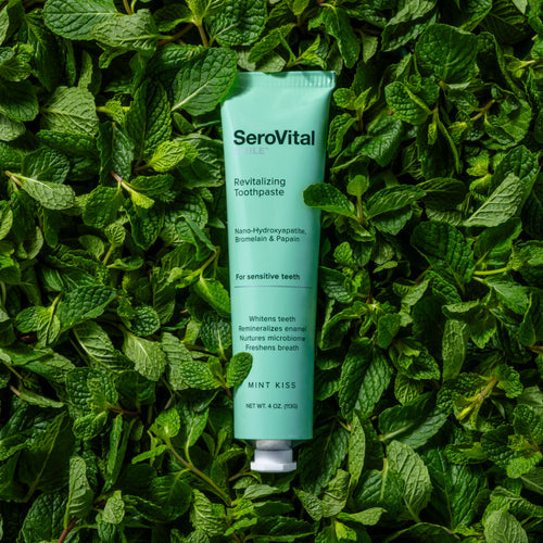 SeroVital toothpaste tube on a bed of green leaves