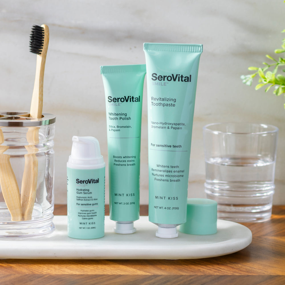 SeroVital dental care products including toothpaste, polish, and serum on a tray with a toothbrush and glasses.