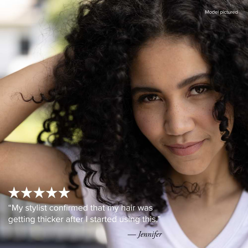 Close-up photo of a smiling woman with dark, thick, curly hair, demonstrating the products results. Below the image is a five-star rating and a quote attributed to Jennifer: "My stylist confirmed that my hair was getting thicker after I started using this." The text "Model pictured" is in the top right corner.