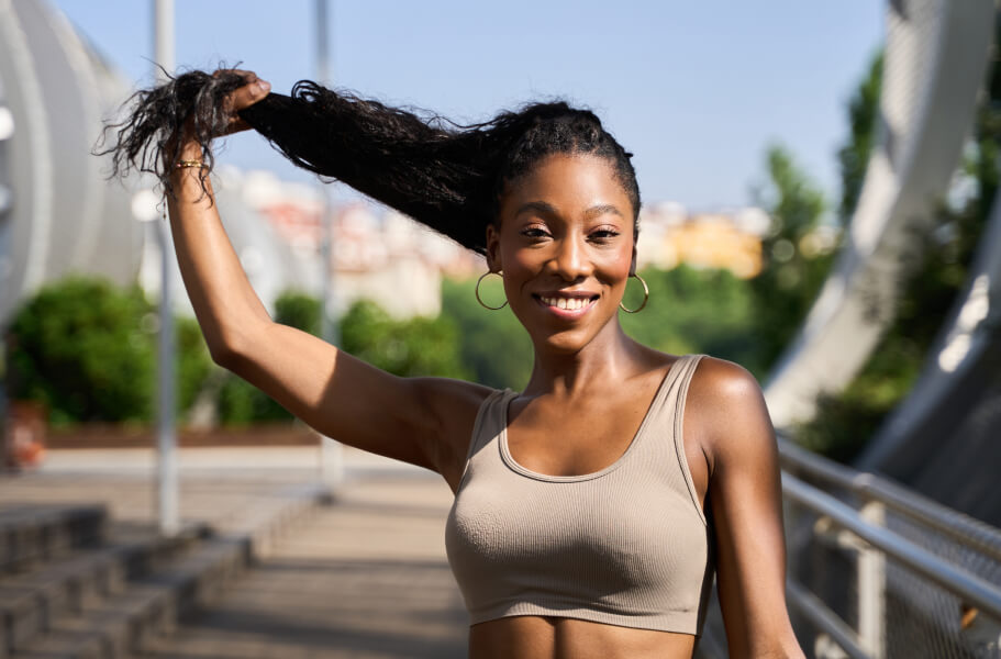 Woman in a sports bra top outdoors on a sunny day