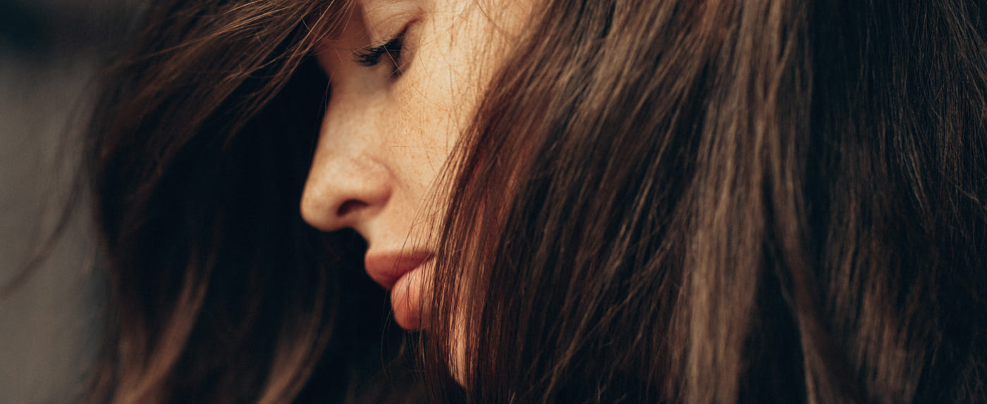 Close-up of a person with long brown hair, focusing on the hair texture.