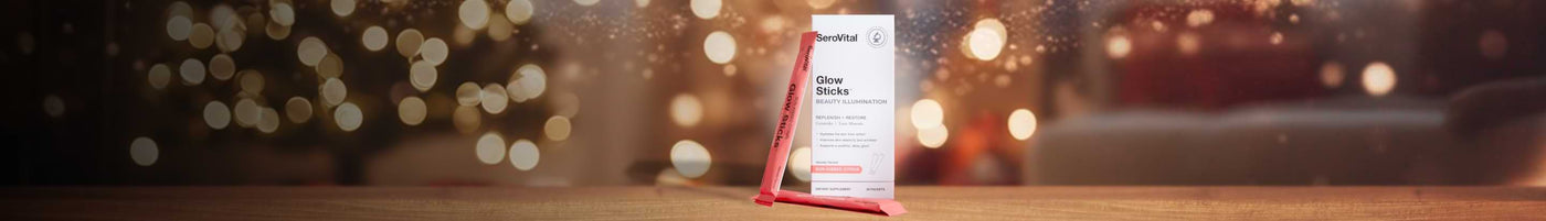 SeroVital Glow Sticks beauty supplement box standing on a wooden surface with a festive, blurred holiday lights background