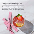 Strawberry lemonade drink with pink packets on a marble surface