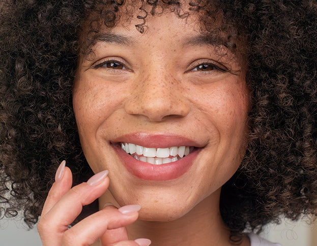 Close-up of a person with curly hair smiling